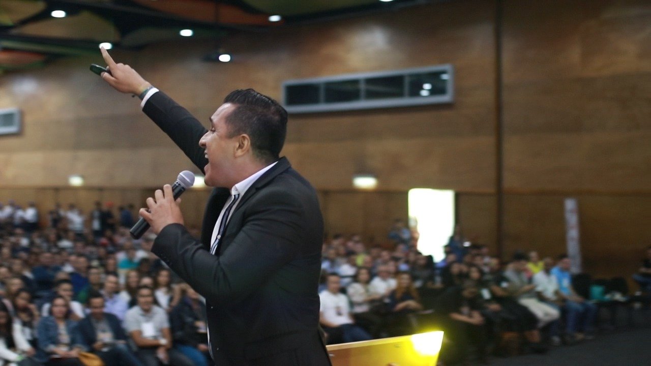 Carlos Laguna en conferencia frente a auditorio lleno